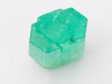 un gros plan d'un morceau de jade vert sur une surface blanche