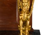 a gold statue of a sphinx on a marble base