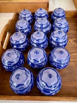 de nombreux bocaux en verre bleus et blancs dans une caisse en bois