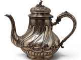 a silver tea pot with a handle on a white background