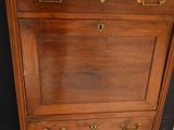 a tall wooden cabinet with brass handles and drawers