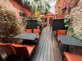many tables and chairs on the wooden floor of this restaurant