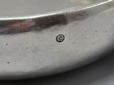 a silver plate with a silver handle on a table