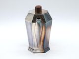 a silver vase with a wooden handle on a white surface