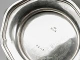 an antique silver plate on a table with a black background