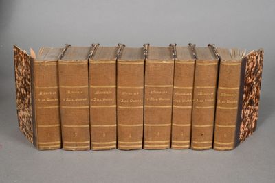 several old books are stacked on top of each other on a table