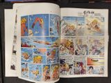 a comic book open on a table with comics on it