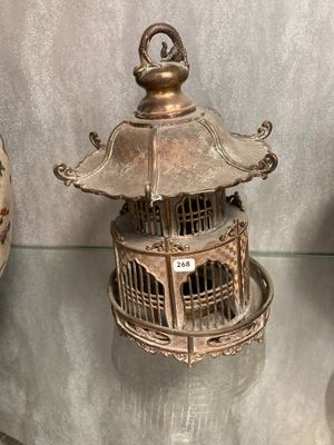 une cage à oiseaux contenant un oiseau, exposée au public