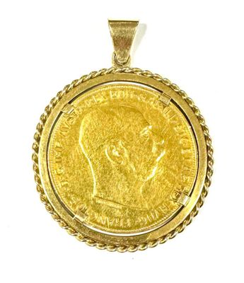 a close up of a gold coin pendant on a white background