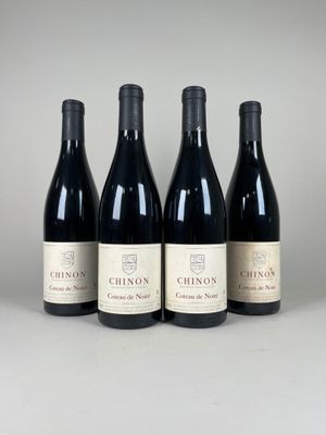 quatre bouteilles de vin sont alignées sur une table