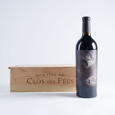 la bouteille de vin se trouve à côté d'une caisse en bois, posée sur une surface blanche