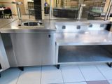 a large stainless steel counter with a sink and a dishwasher
