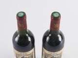 two bottles of wine sitting next to each other on a table