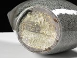 a close up of a vase on a white surface