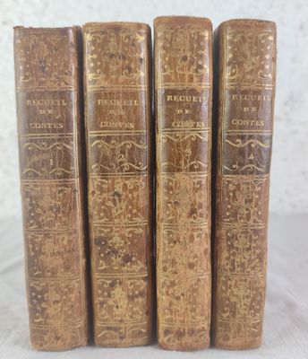 quatre vieux livres posés les uns à côté des autres sur une table