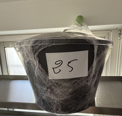 une poubelle noire entourée d'une toile d'araignée