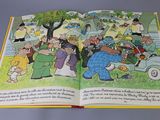 an open book with a picture of people in a park