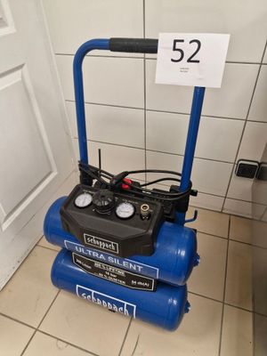 a blue air compressor sitting on the floor in the bathroom