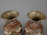two vases that are sitting side by side on a table