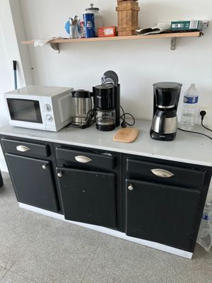 two microwaves and a coffee maker on a kitchen counter