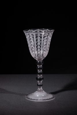 a wine glass sitting on a table with a black background