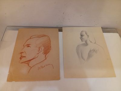 Deux dessins représentant un homme et une femme sont posés sur une table.