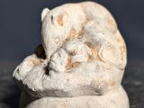 une petite statue représentant un chat assis sur une table