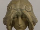 a sculpture of a woman ' s face on a stand