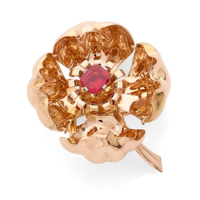 une image montrant un gros plan d'une bague en or sertie d'une pierre rouge