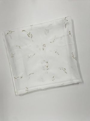 une serviette blanche à motifs posée sur une surface blanche