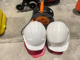 deux casques de chantier et une paire de casques de chantier posés par terre