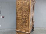 a wooden cabinet on wheels in the middle of a room