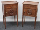 une paire de tables de chevet anciennes en bois, ornées de sculptures sur le dessus