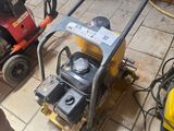 un homme debout à côté d'une petite machine posée au sol