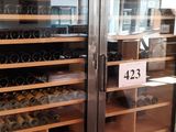 Des bouteilles de vin sont exposées derrière des portes vitrées dans un caviste.