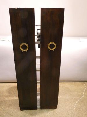 pair of wooden speakers sitting on top of a floor next to a white wall