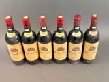 six bottles of wine are lined up in a row on a table