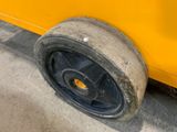 a close up of a tire on the side of a yellow bus