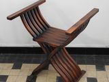 a wooden chair that is on a tiled floor
