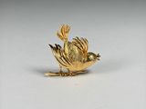 a gold bird that is sitting on a white surface