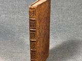 un vieux livre à la couverture en bois posé sur une table