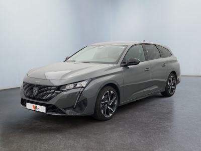 Une voiture grise est garée dans une pièce aux murs blancs.