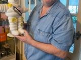 smiling man holding a stuffed animal in front of a glass display case