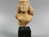 une petite statue représentant une femme aux cheveux longs, posée sur un socle en bois