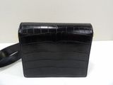 the small black bag is sitting on a white surface
