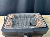 a grill that is sitting on a wooden table