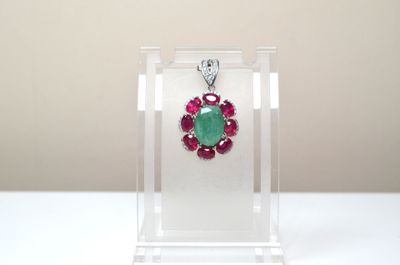 un gros plan sur un collier orné d'une pierre verte et rouge