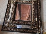 un miroir accroché au mur à côté d'un vase de fleurs