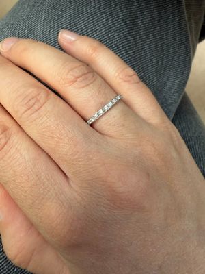 une femme qui porte une bague en diamant au doigt