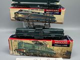trois trains miniatures dans leurs boîtes, empilés les uns sur les autres sur une table